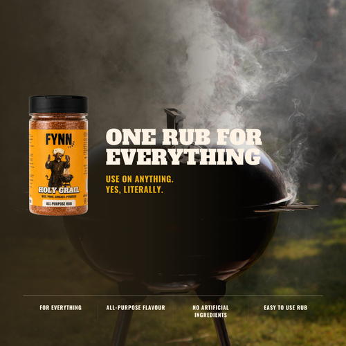 A jar of Fynn Holy Grail All Purpose Rub shown next to a black kettle grill with smoke rising in an outdoor setting. The product label is yellow and black, and the image features marketing text that reads 'ONE RUB FOR EVERYTHING' and 'USE ON ANYTHING.
