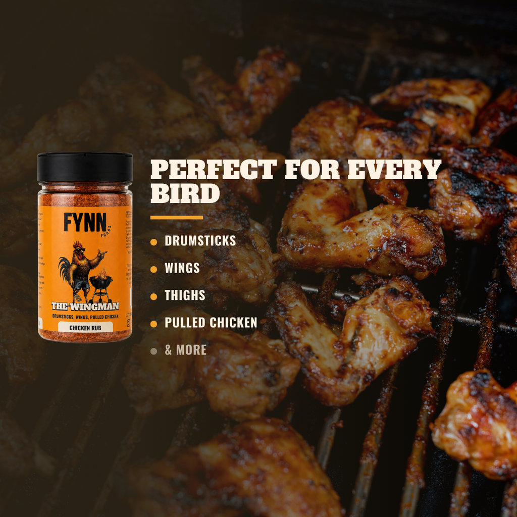 A jar of Fynn The Wingman Chicken Rub seasoning is shown on the left against a background of grilled chicken on a barbecue grill. Text on the right reads 'PERFECT FOR EVERY BIRD' with bullet points listing drumsticks, wings, thighs, pulled chicken, and more.