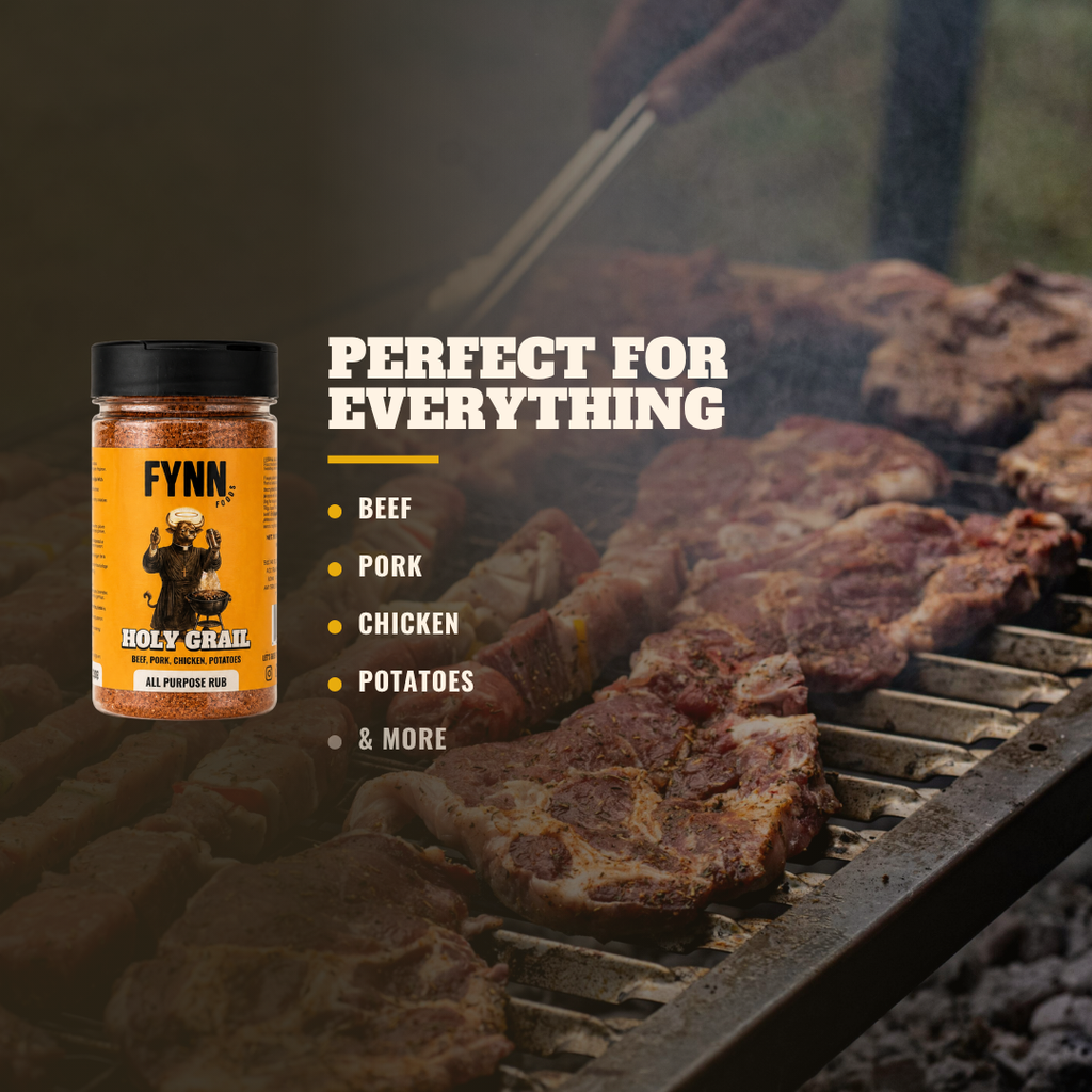 A jar of Fynn Holy Grail All Purpose Rub on the left, set against a background of meat grilling on a barbecue grill with smoke. White text on the right reads 'PERFECT FOR EVERYTHING' with bullet points listing 'BEEF', 'PORK', 'CHICKEN', 'POTATOES', and '& MORE'.
