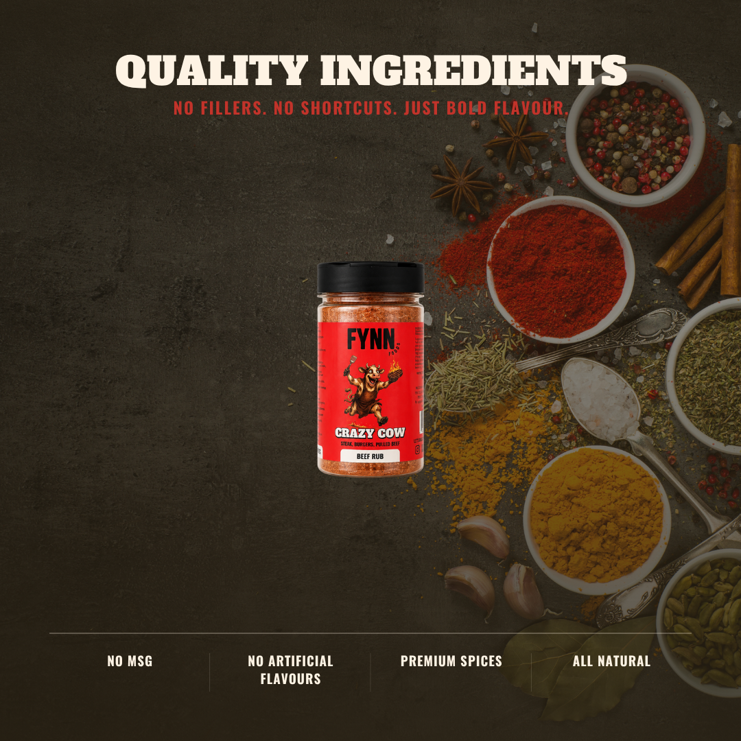 A jar of Fynn Crazy Cow Red Spice mix is centered on a dark textured background, surrounded by bowls of colorful spices like red chili powder, yellow turmeric, green herbs, garlic cloves, star anise, and cinnamon sticks. Text at the top reads 'QUALITY INGREDIENTS' and text at the bottom highlights 'NO MSG', 'NO ARTIFICIAL FLAVOURS', 'PREMIUM SPICES', and 'ALL NATURAL'.