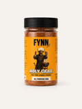 A bottle of Fynn Food Holy Grail All Purpose Rub seasoning, featuring a bright orange label with a black lid and an illustration of a devil, on a light beige background.